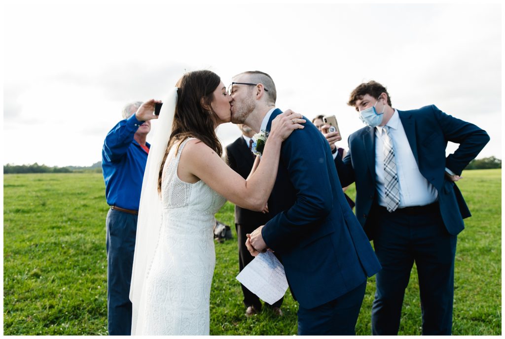 bride and groom kissing at farm house inn wedding
