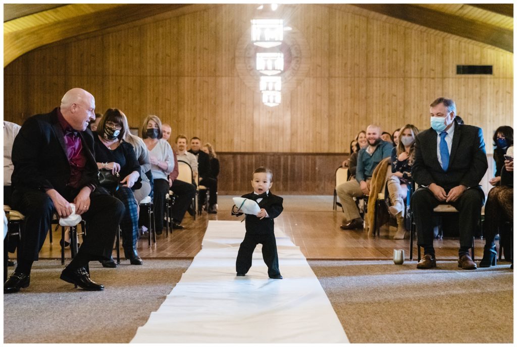 adorable baby ring-bearer coming down aisle during wedding ceremony at laube hall, freeport, pa