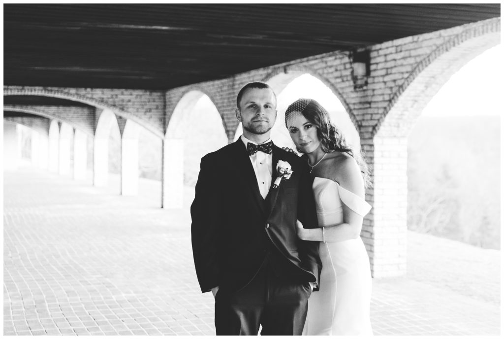 bride and groom under arches at at laube hall, freeport, pa