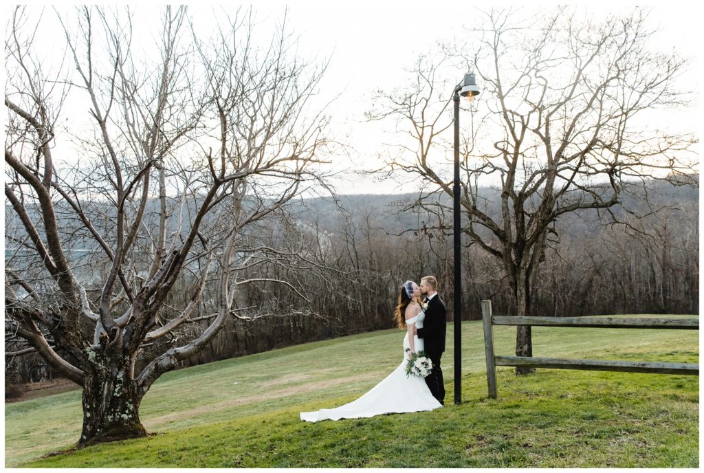bride and groom under lamp post kissing at laube hall, freeport, pa