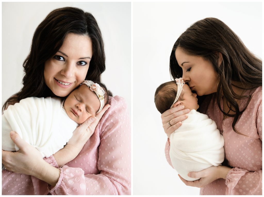 mom holding and kissing newborn girl at bridgeville newborn photographer studio