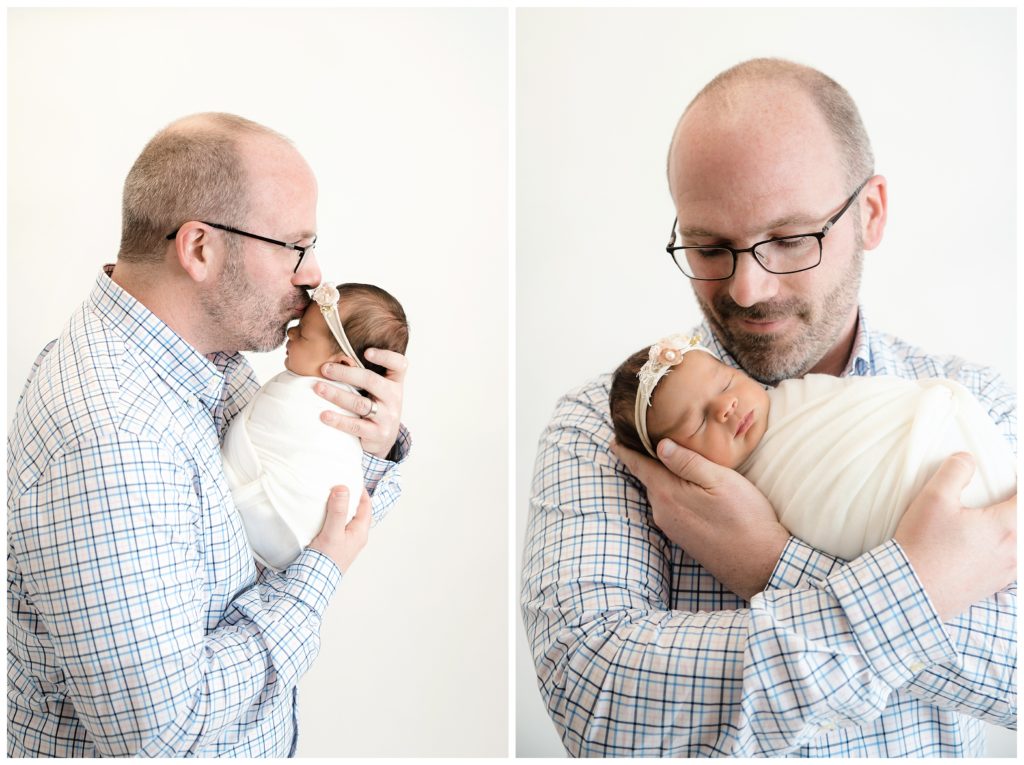 dad kissing and holding newborn girl at bridgeville newborn photographer studio