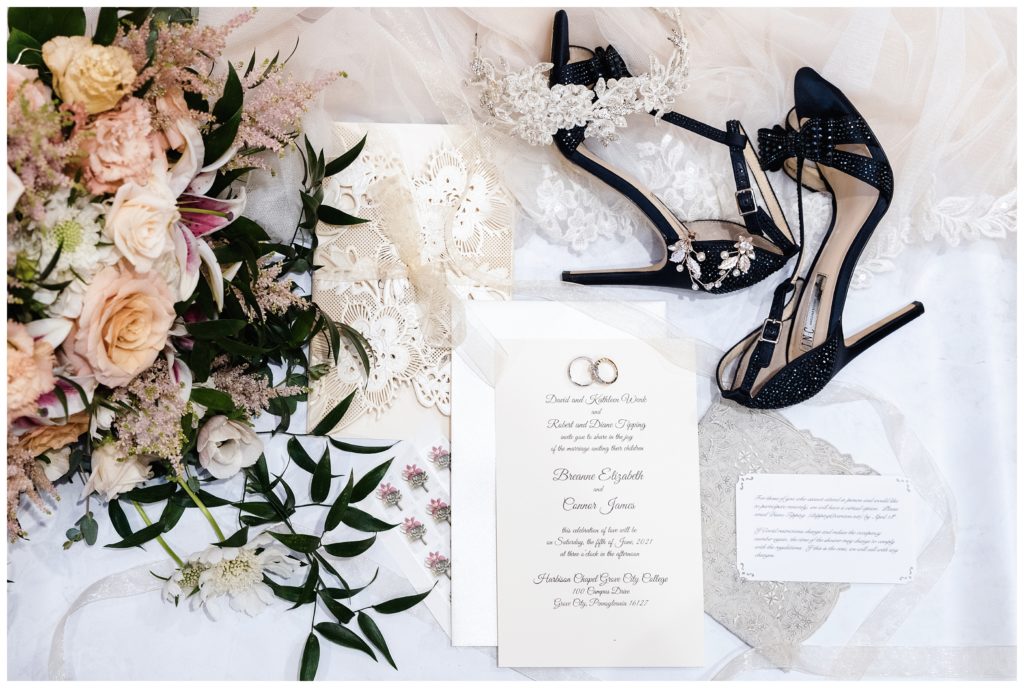 invitation, floral bouquet, bride's shows and accessories all laid out together