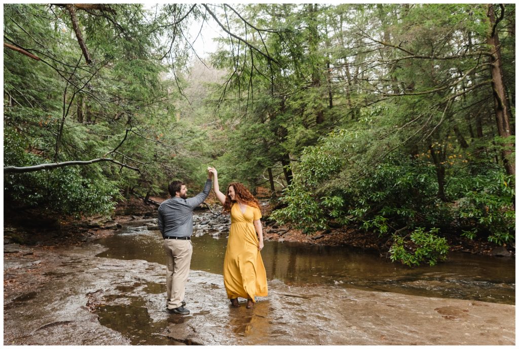 man twirls woman in yellow dress during engagement session