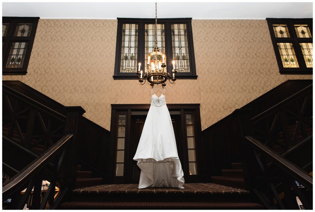 bride's gorgeous dress hanging from chandelier at the summit inn