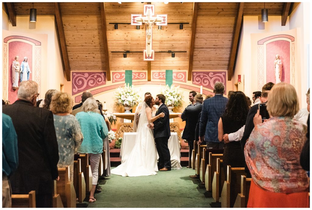 bride and groom sharing first kiss as husband and wife at st. joseph's church in uniontown