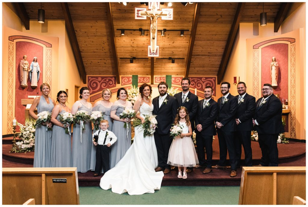 bridal party posing on altar at st. joseph's church in uniontown