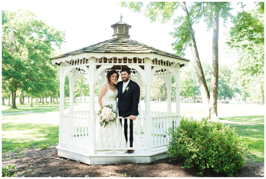 bride and groom stand in white gazebo at lakeview golf resort