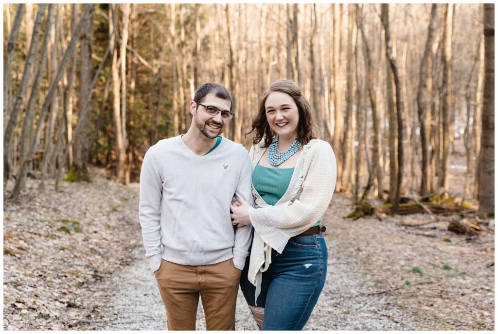 engaged couple walking in woods
