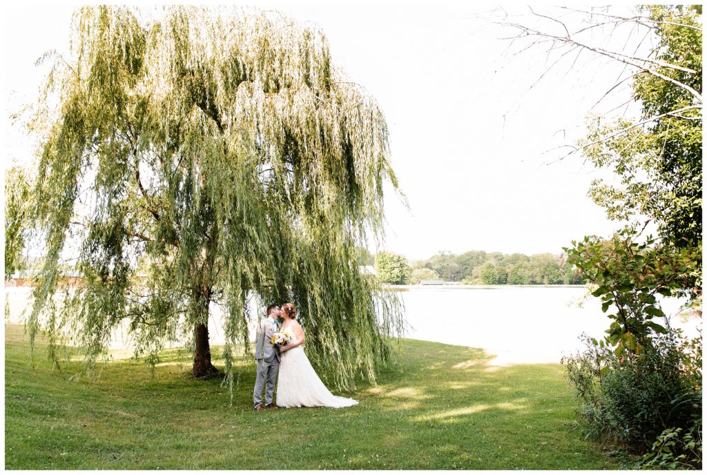 bride and groom in front of willow tree