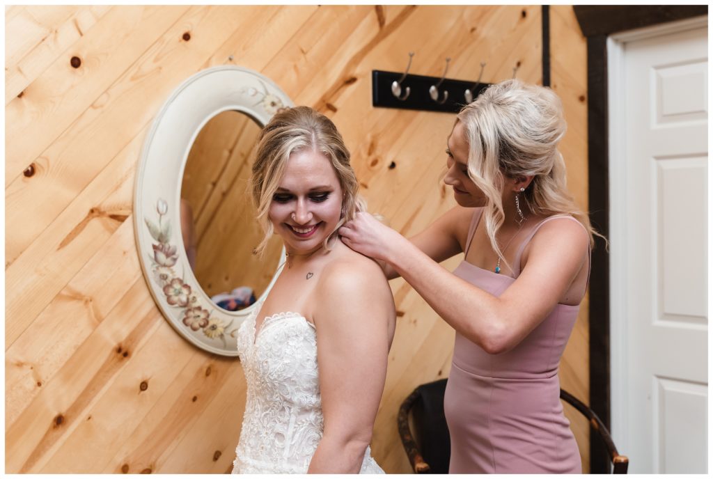 sister helping bride with necklace