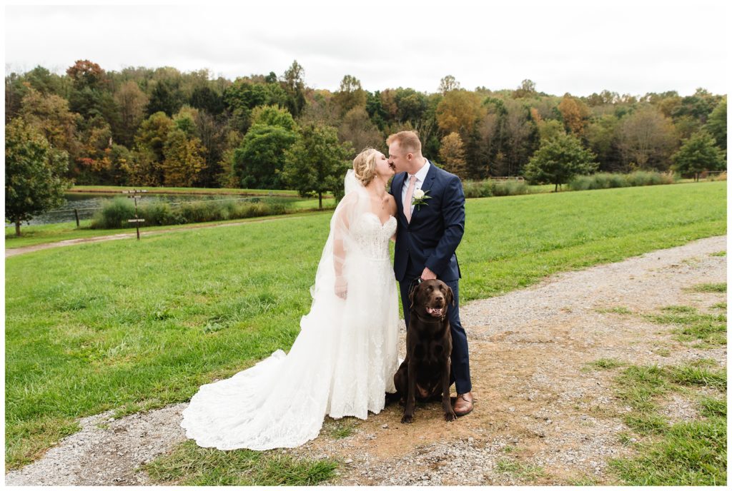bride and groom kissing with dog