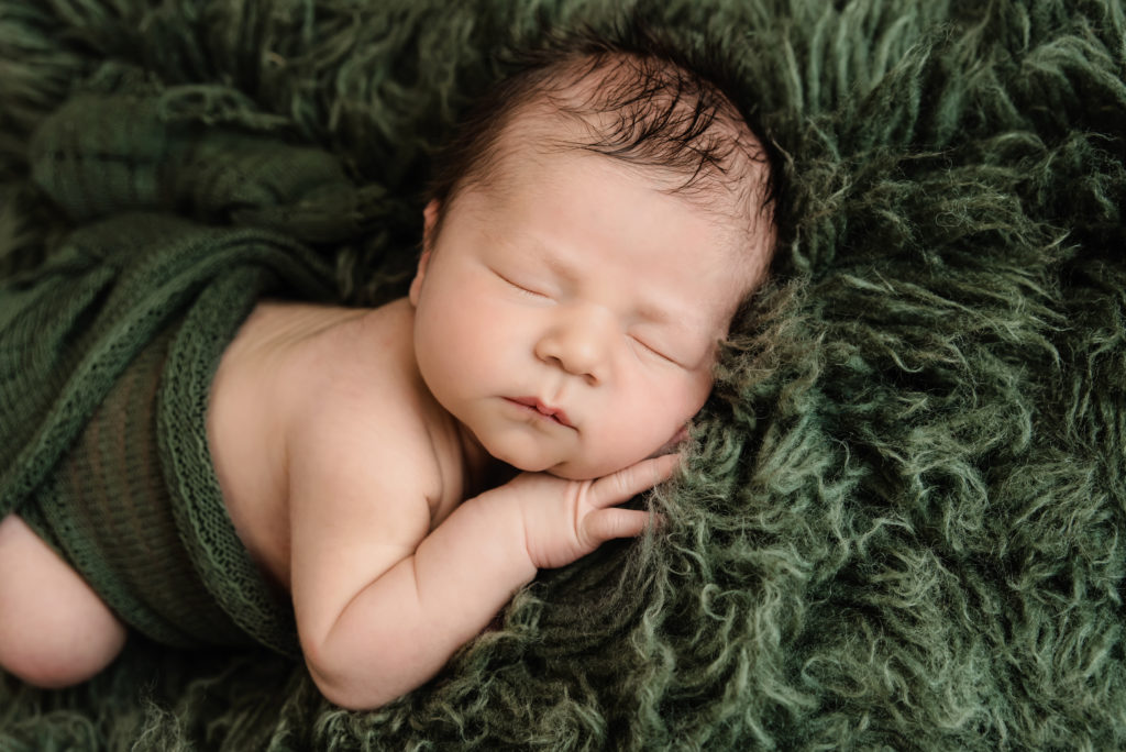 Newborn boy in a tummy pose on green flokati | Pittsburgh Newborn Photographer