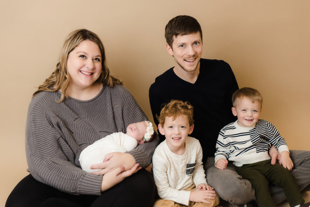 family  sitting holding newborn girl