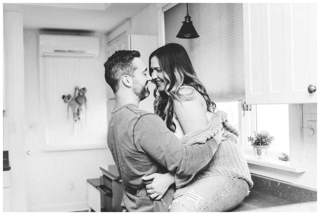 black and white image of engaged couple hugging and smiling at each other