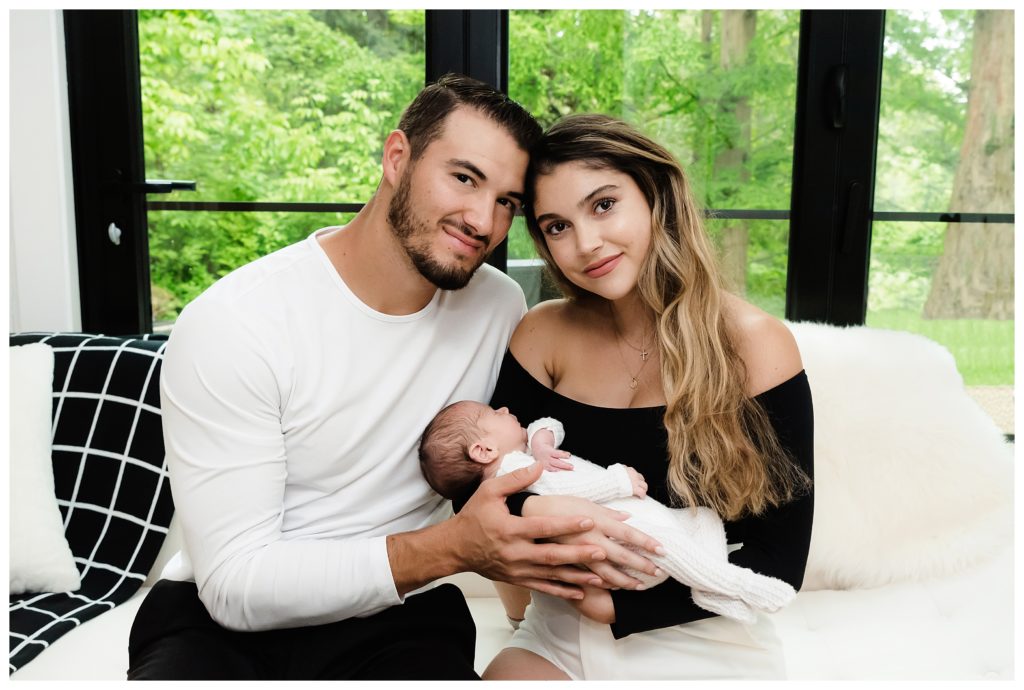 Mitch Trubisky and wife hug baby Hudson in nursery during lifestyle photo session in Pittsburgh, PA.
