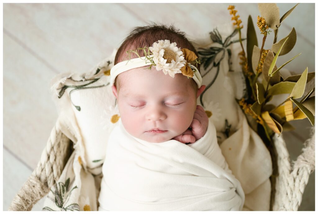 Closeup of baby girl sleeping with little sunflower headband.