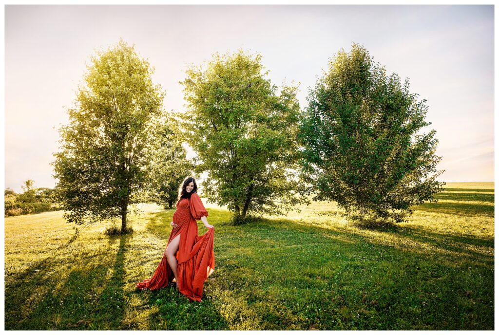 Pregnant mom wears rust Reclamation dress while posing at Fairview Park.