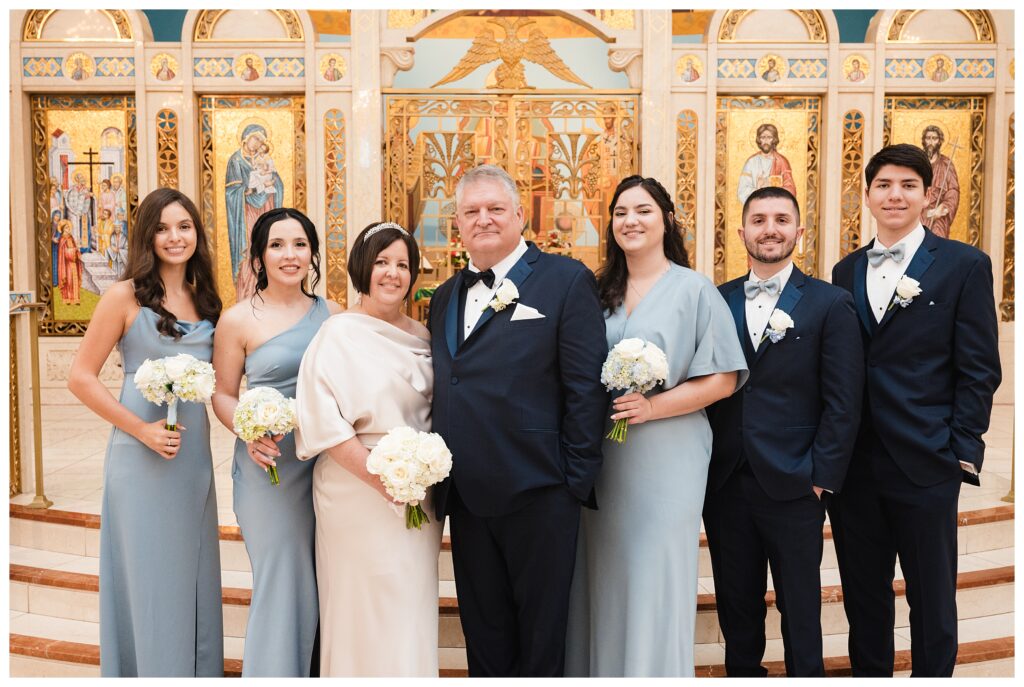 Bride and groom pose with their children on altar at Holy Cross Greek Orthodox Church.