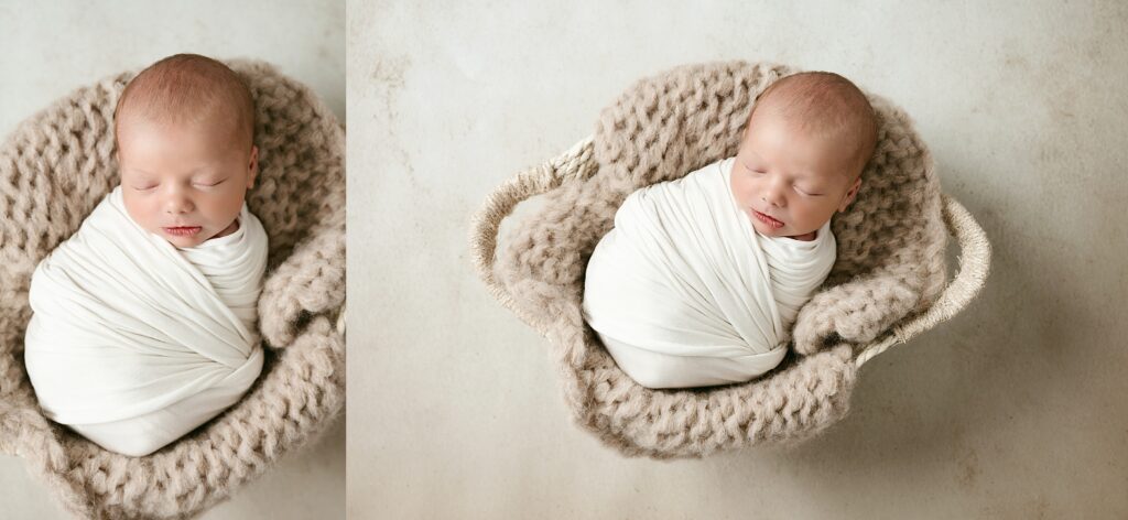 Newborn boy swaddles in white and sleeping in a white basket with handles on a tan chunky blanket.